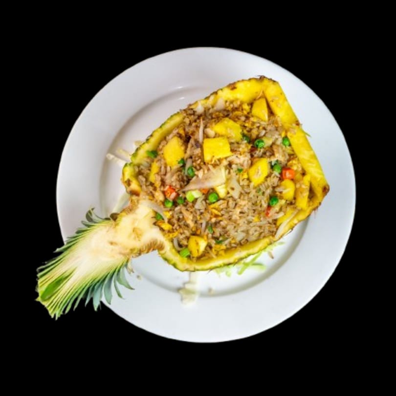 Canton Bistro's pineapple fried rice, served in a hollowed-out pineapple on a white plate.